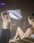 Woman relaxing in sauna, man holding towel in background