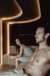 Man and woman relaxing in a modern sauna with warm lighting