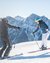 Two skiers practicing together on snowy slope with mountains in the background