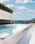 Modern infinity pool with mountain view and clear blue sky