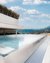 Modern infinity pool with mountain view and clear blue sky