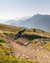 Mountainbiker fährt auf kurviger Strecke in bergiger Landschaft