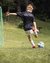 Kind schießt Fußball auf Torwart im Fußballcamp