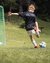 Bambino calcia un pallone durante un campo di calcio