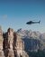 Helicopter flying near steep rocks in mountainous landscape
