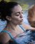 Donna rilassata nell'acqua di una piscina con occhi chiusi