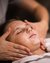 Woman receiving a facial massage with cream at a spa