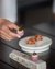 Person holding a small, artfully prepared appetizer