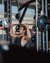 Uomo che solleva pesi in palestra con l'aiuto di un allenatore