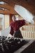 Man in red robe waving towels inside sauna room