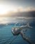 Woman swimming underwater with sunlight at the water surface