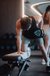 Man exercising with 30kg dumbbell on bench in gym