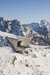 Edificio moderno in cemento in paesaggio montano innevato con Alpi sullo sfondo