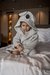Toddler sitting on bed wearing cozy animal-themed bathrobe