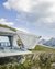 Modern mountain viewing platform overlooking peaks with two people standing