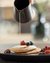 Pancake con frutti di bosco e sciroppo su piatto nero